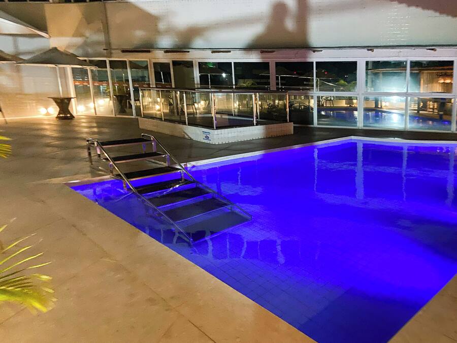 A swimming pool with a glass barrier and steps leading into it.