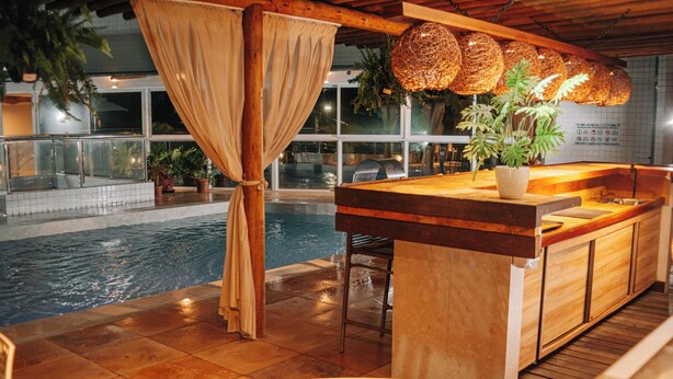 An indoor pool area with a bar and seating. - BALI MAR HOTEL (Natal)