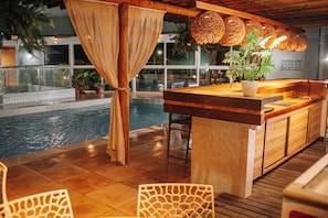 An indoor pool area with a bar and seating. - BALI MAR HOTEL (Natal)