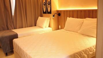 Una habitación de hotel con dos camas, una mesita de noche, una lámpara de pared y un cuadro.