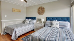 A bedroom with two beds, a ceiling fan, a decorative wall piece, and a sign on the wall. - Walk to Shore: Wildwood Crest Studio w/ Pool View! (Wildwood Crest)