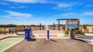 A beachside walkway with a trash can, benches, and a signboard. - Walk to Shore: Wildwood Crest Studio w/ Pool View! (Wildwood Crest)