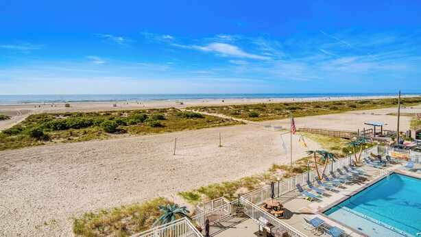A beach view with a pool area, including a pool, lounge chairs, and a lifeguard stand. - Beachfront Condo in Wildwood Crest w/ Pool Access! (Wildwood Crest)
