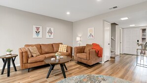 A modern living room with two brown sofas, a coffee table, and a patterned rug. - County Club Townhome *Packman Game, Xbox, Golf course Views, Near Forest Edge (Flagstaff)