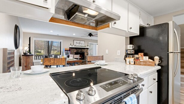 A modern kitchen with a central island, stainless steel appliances, and a coffee bar sign. - County Club Townhome *Packman Game, Xbox, Golf course Views, Near Forest Edge (Flagstaff)