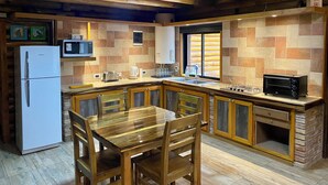 A compact kitchen with a refrigerator, microwave, toaster, and a built-in oven.