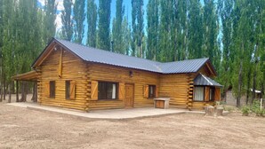 A log cabin with a metal roof, wooden exterior, and a small porch.