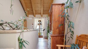 A narrow hallway with wooden walls and ceiling, a wooden cabinet, and a bed with a stuffed toy. - Room 'La Gemma - Stanza Del Fieno' with Mountain View, Shared Garden and Wi-Fi (Sant'Orsola Terme)