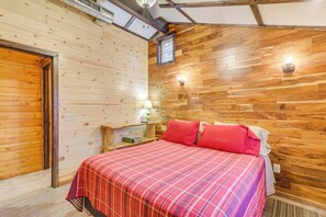 Una stanza con rivestimento in legno, un letto, un comodino e una finestra.