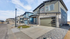Una calle residencial con casas modernas que incluyen garajes y entradas para vehículos.