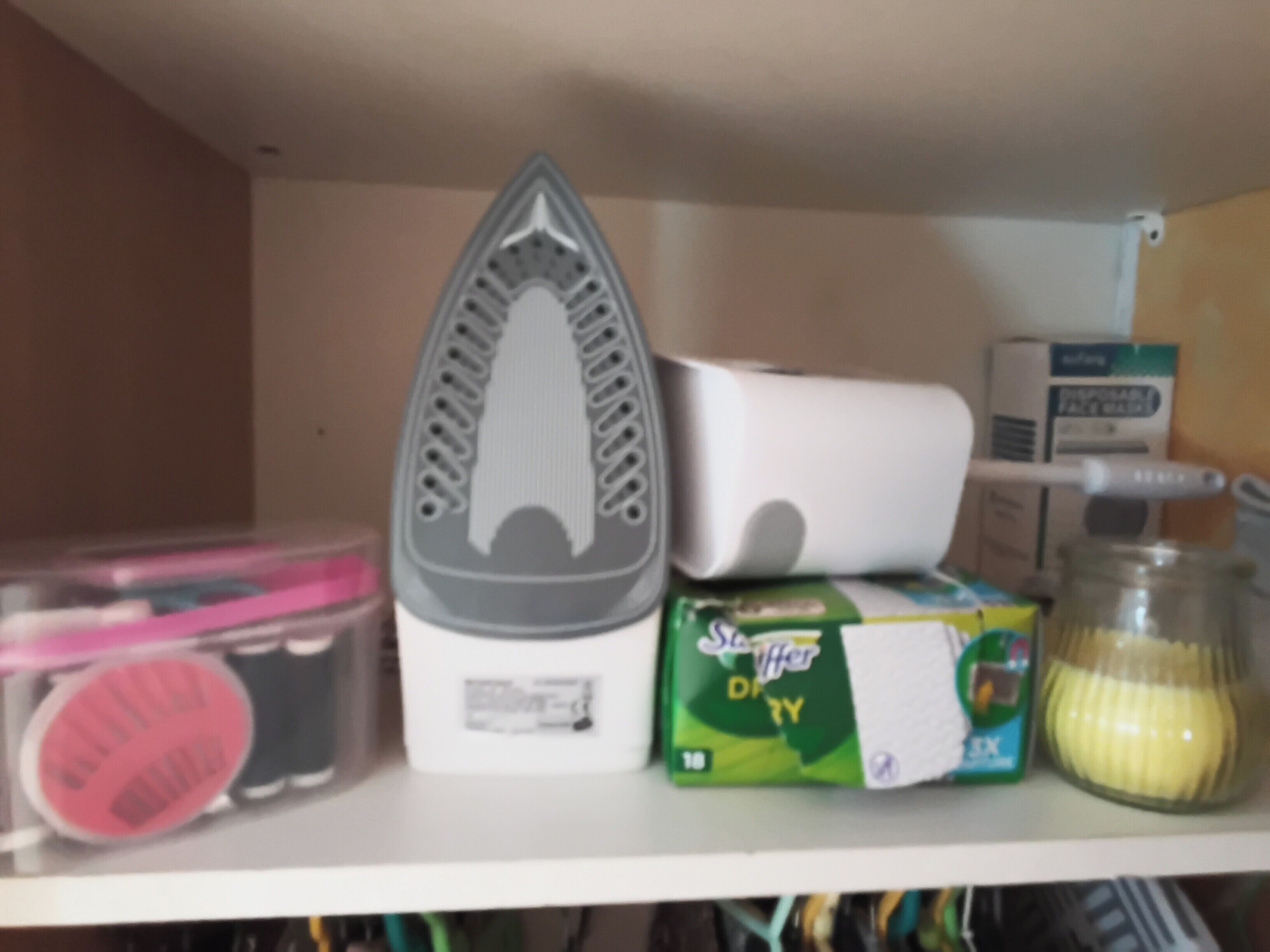 Una estantería con un calentador, una caja de detergente Scotch Dry y un tarro de jugo de limón.
