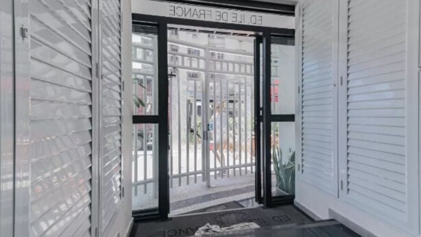 A modern entrance with glass doors and metal shutters, leading to a street view. - SUH Copacabana 40 Smart Beach (Rio de Janeiro)