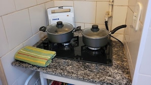 A kitchen with two gas stoves, a microwave, and a striped towel on the counter. - SUH Copacabana 40 Smart Beach (Rio de Janeiro)