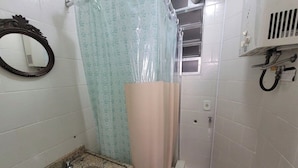A bathroom with a sink, mirror, shower curtain, and a towel rack. - SUH Copacabana 40 Smart Beach (Rio de Janeiro)