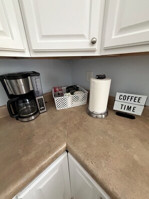 A kitchen with a coffee maker, a basket, a paper towel holder, and a sign that reads 'COFFEE TIME'. - House with JACUZZI * Luxury * 3BR. { ExclusiveDiscounts } (Charlotte)