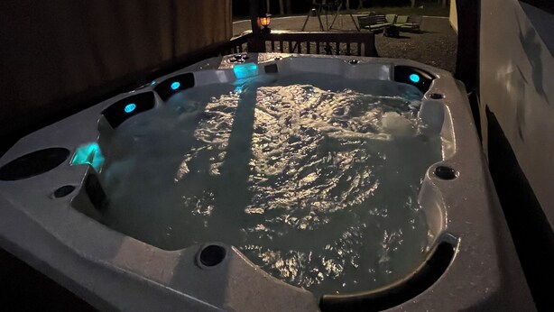A hot tub with a wooden deck and a covered area.