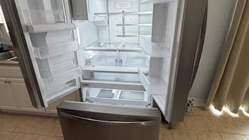 An open refrigerator with multiple shelves and drawers, a water dispenser, and a control panel.