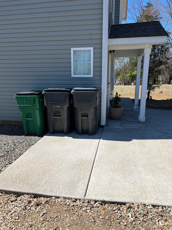 Three trash bins outside a house with a porch. - House with JACUZZI * Luxury * 3BR. { ExclusiveDiscounts } (Charlotte)