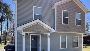 A two-story house with a front porch, a mailbox, and a number '13210' on the front.