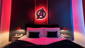 Un dormitorio con una cama, dos mesitas de noche y un logotipo en la pared.