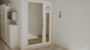 A room with a sliding glass door, a small cabinet, and a wall-mounted electrical outlet. - Rainbow Relax Home by MONHOLIDAY (Monopoli)