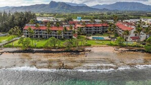 A resort with multiple buildings, a beach, and mountains in the background. - WorldMark Kapaa Shore - 2 Bedroom (Kapaa, Kauai)
