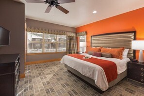 Relax in a spacious room with a large bed, ceiling fan, and television.