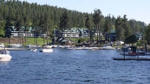A marina with boats, a forested hill in the background, and a large building with multiple stories. - WorldMark Arrow Point - 3 Bedroom Accessible (Harrison)