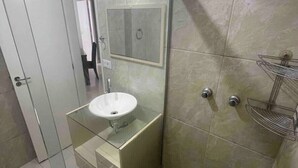 A modern bathroom with a glass-enclosed sink, a shower, and a towel rack. - SUH Copacabana 46 Classy Rio (Rio de Janeiro)