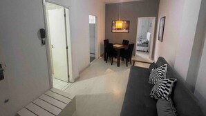 A compact living space with a sofa, a dining table, and a ceiling fan. - SUH Copacabana 46 Classy Rio (Rio de Janeiro)