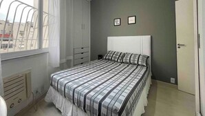 A bedroom with a bed, a window with curtains, a wardrobe, and a door. - SUH Copacabana 46 Classy Rio (Rio de Janeiro)