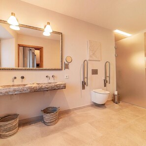 A bathroom with a marble sink, a large mirror, a toilet, and a shower. - Origins Hotel Boutique (Arta)