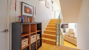 Un espace de vie moderne avec un escalier en bois, une bibliothèque et un canapé.