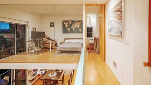 Une chambre moderne avec un grand lit, un bureau et une cloison en verre.