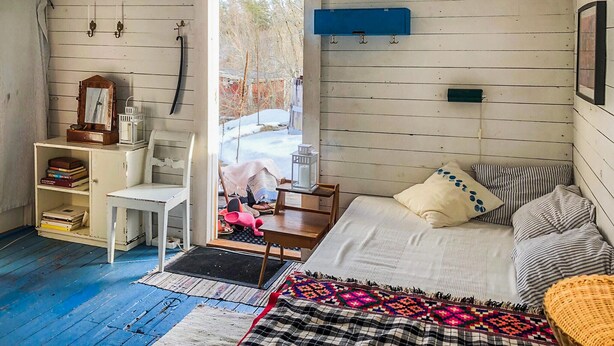 Een gezellige kamer met een bed, een stoel, een bureau en een raam.
