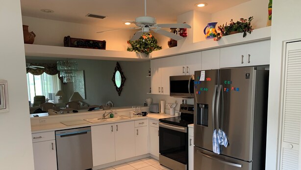 A modern kitchen with white cabinets, stainless steel appliances, and a dishwasher.