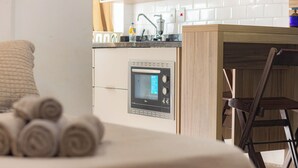 Una cucina moderna con forno integrato, un tavolo in legno e una sedia.