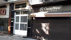 Un negozio chiuso con un cartello che riporta 'Broadway' e un altro cartello per 'CacauShow'.