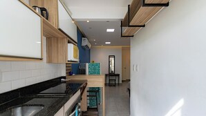 Una cucina moderna con un piano di lavoro nero, mobili in legno e una schiena a parete rivestita di piastrelle.