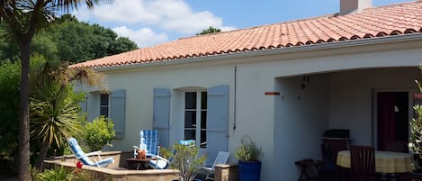A house with a tiled roof, a covered patio, and a pool.