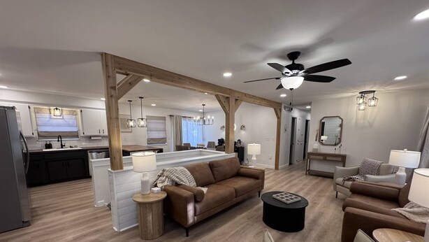 A spacious living area with a sofa, a coffee table, and a dining area with a kitchen in the background.