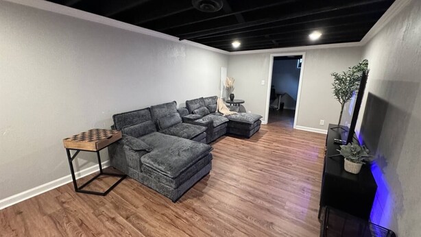 A modern living room with a sectional sofa, a small wooden table, and a flat-screen TV. - Radian Ranch - 2 Kings, Near Derby - Fenced Yard - Pet Friendly. (Wichita)