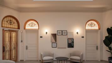 A lobby with two armchairs, a small table, and a wall with framed artwork.