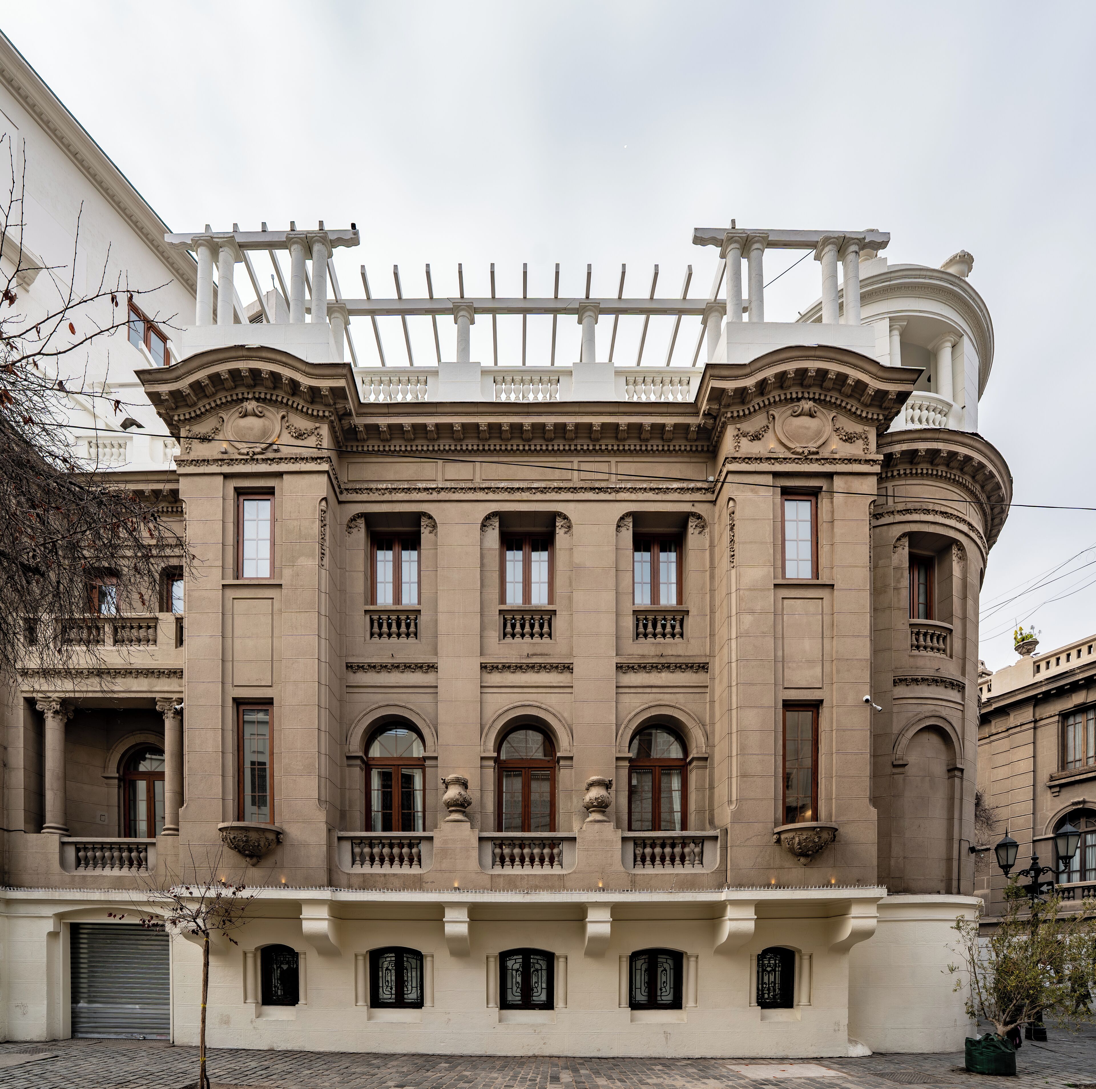 Ein historisches Gebäude mit klassischer Architektur, das einen Balkon mit Balustraden, mehrere Fenster und einen zentralen Eingang zeigt.