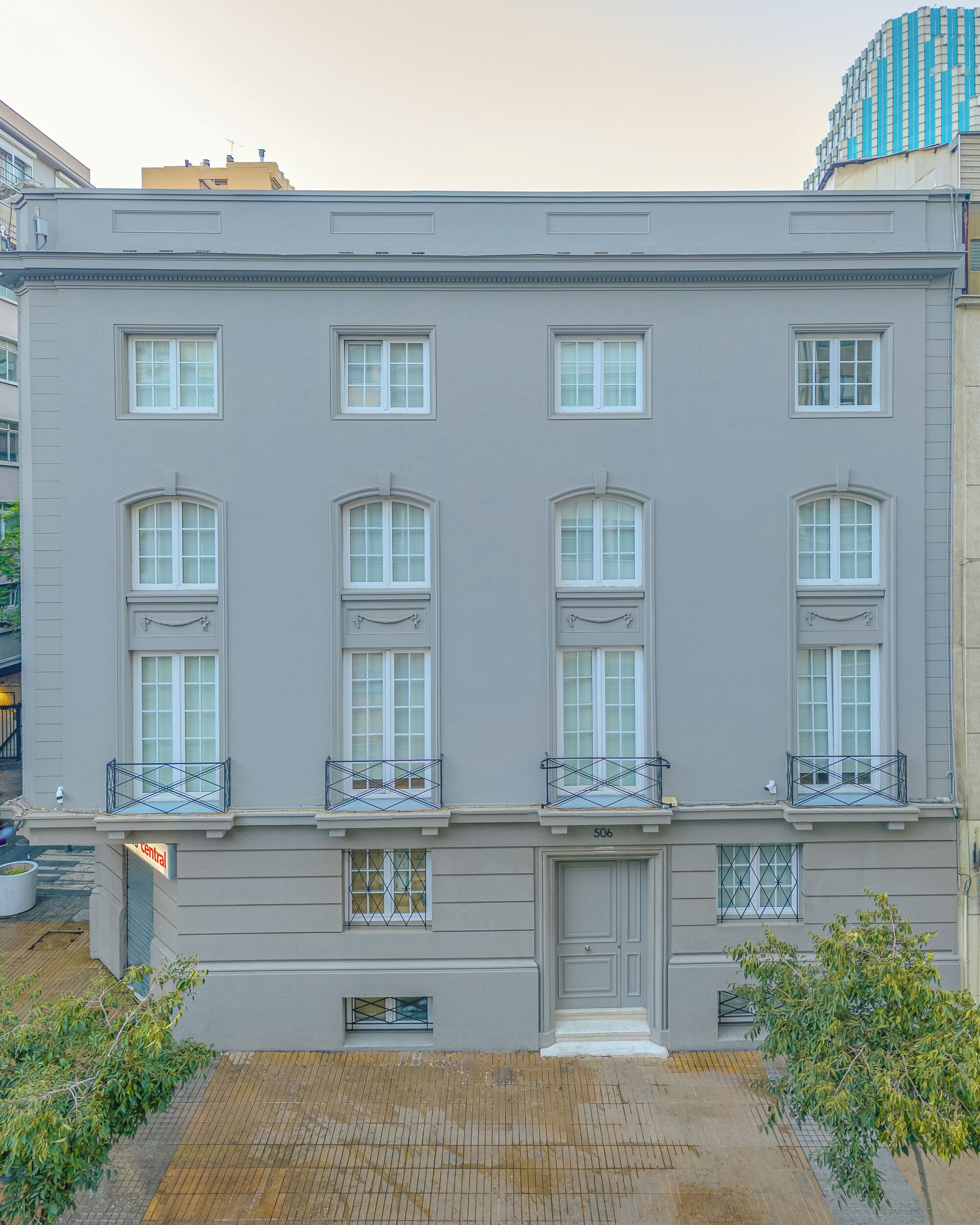 A multi-story building with a symmetrical facade, large windows, and a central entrance.