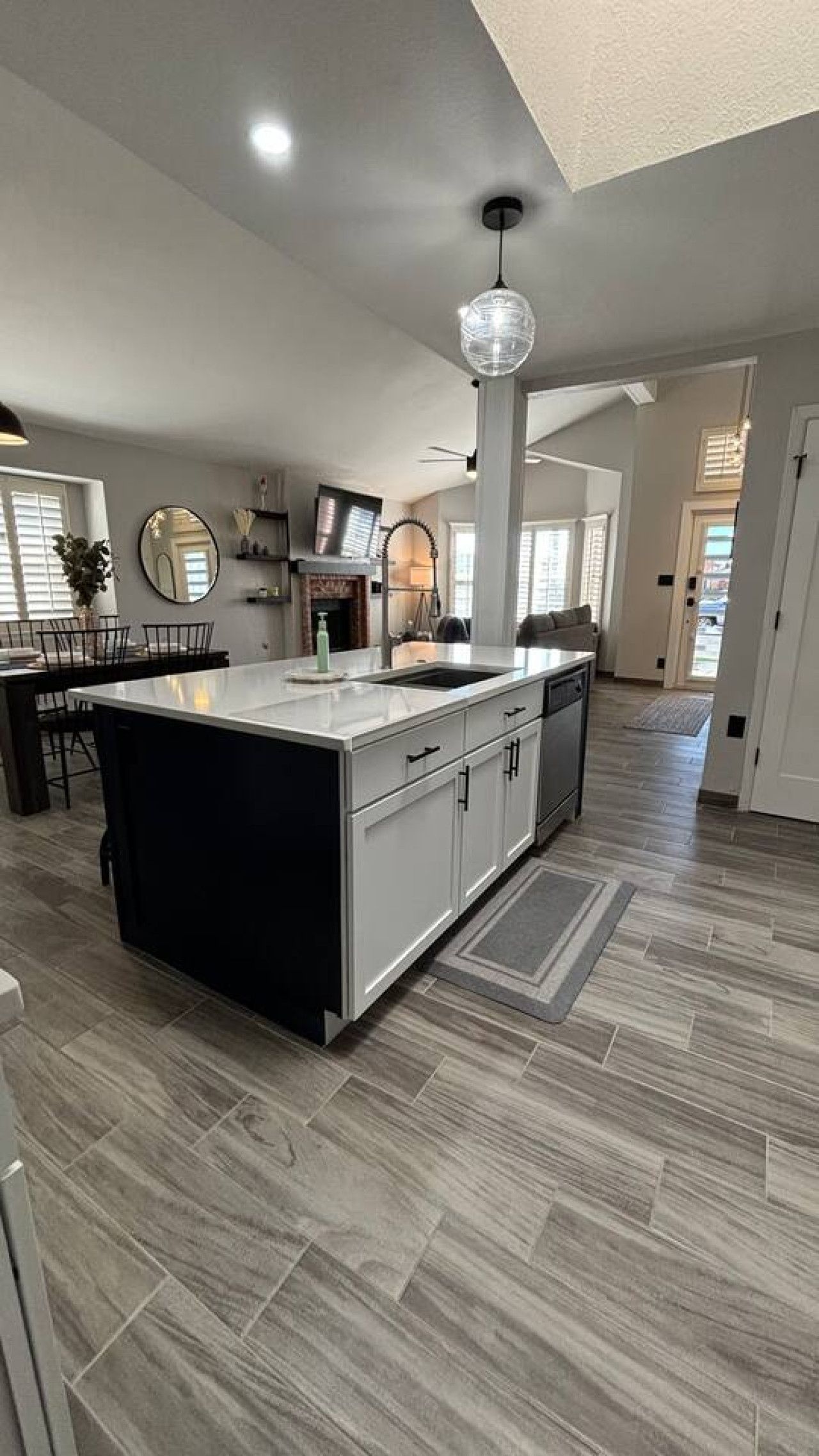 A spacious kitchen with a large island, modern appliances, and a high ceiling with recessed lighting.