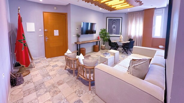 A modern living room with a sofa, chairs, a TV, and a dining area. - Downtown Gem - View of the old medina (Rabat)