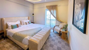 A modern bedroom with a large bed, a round ceiling light, a view of the outdoors, and a framed picture on the wall. - Downtown Gem - View of the old medina (Rabat)