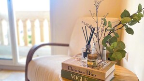 A wooden side table with a book titled "Vogue" and a small vase with a plant. - Downtown Gem - View of the old medina (Rabat)