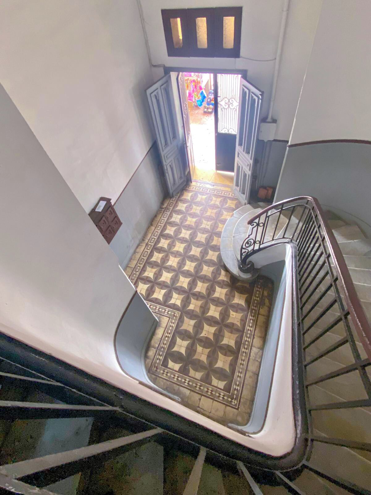 Una scala con pavimento decorato che conduce a un'apertura.